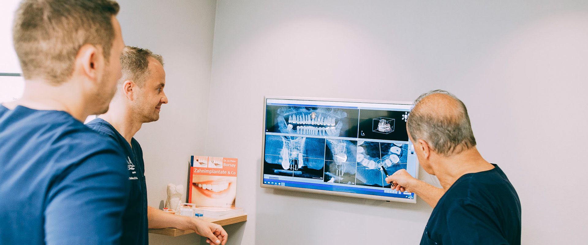 In der Zahnarztpraxis Brückner in Dresden sehen sich die Zahnärzte und Chirurgen Dres. Brückner ein Röntgenbild am Bildschirm an.